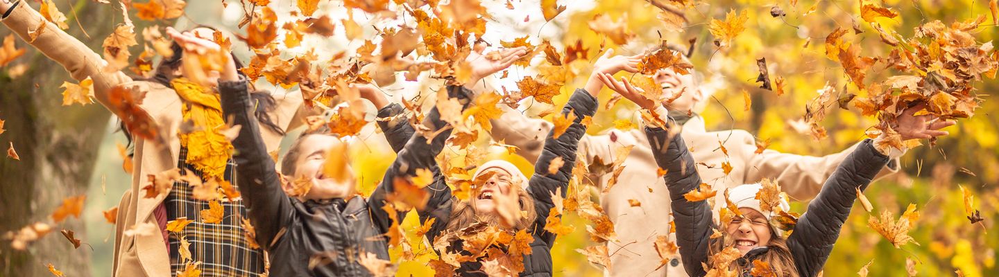 Menschen im Herbst voller Blätter