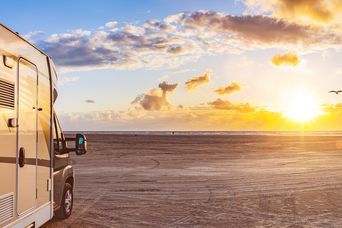 Wohnmobil am Strand beim Sonnenuntergang