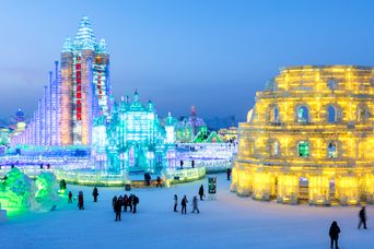 Harbin beim Ice and Snow Festival, Schnee überzogen und mit in Lichtern gekleidete Gebäude