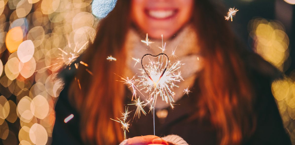 Eine Frau mit einer Wunderkerze in der Hand