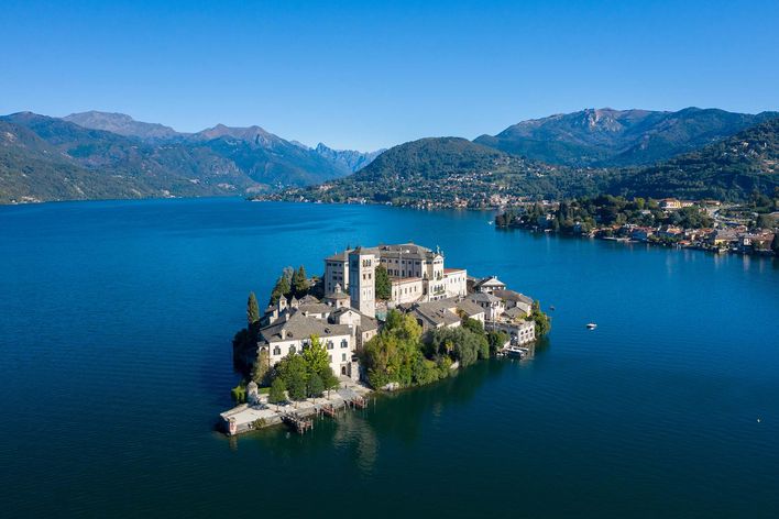 Luftbild auf den Ortasee in der Region Piemont in Italien mit der Insel San Giulio im Zentrum, umgeben von Bergen und Landschaft