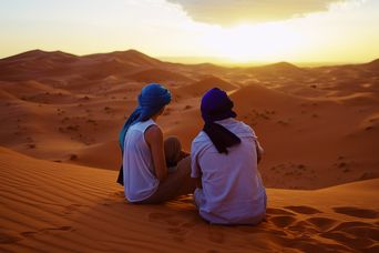 Ein Paar sitzt auf einer Sanddüne in Marokko