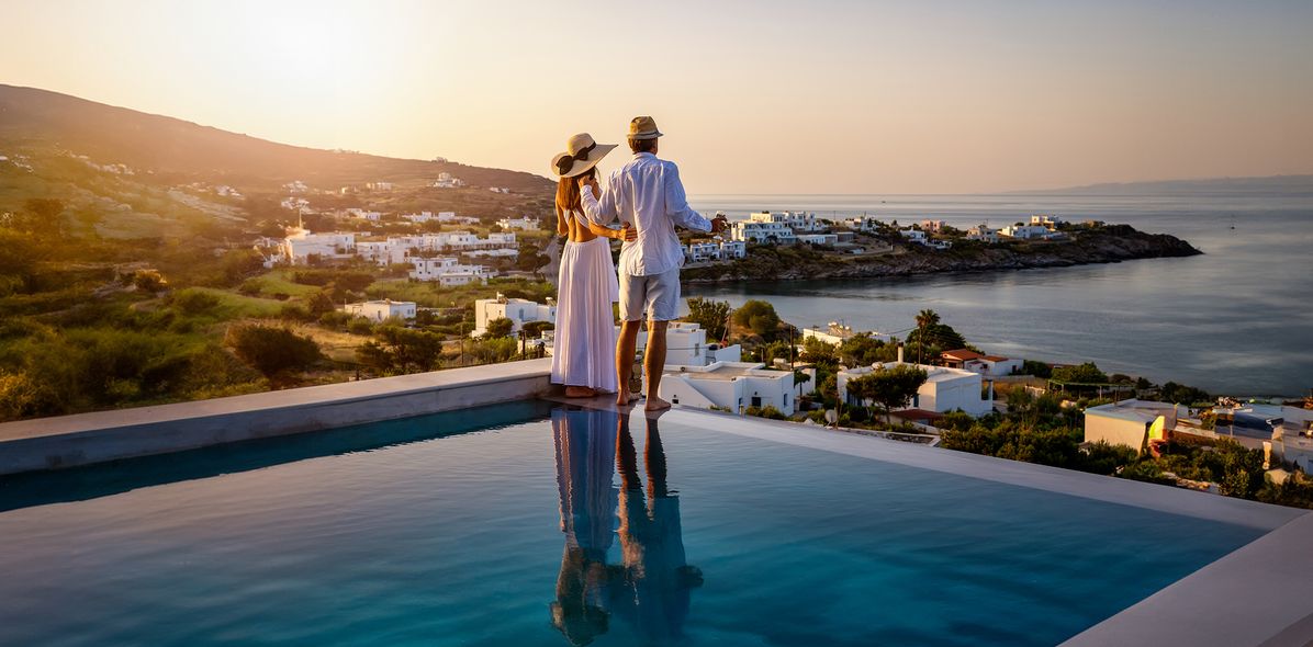 Paar am Pool mit Blick aufs Meer