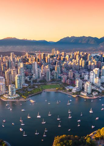 Skyline von Vancouver bei Sonnenuntergang mit Hafen und Bergen