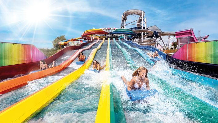 Eine Gruppe junger Mädchen beim Rutschen auf der Rainbow-Racer-Rutsche in der Therme Erding