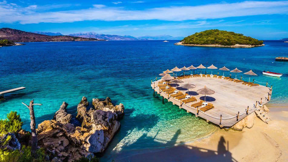 Der malerische Strand von Ksamil an der albanischen Riviera mit türkisfarbenem Wasser und kleinen Inseln