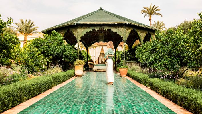 Eine Frau steht in einem Garten in einer Hotelanlage in Marrakesch, Marokko