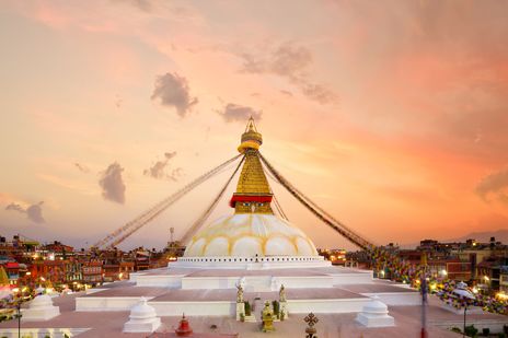 Boudhanath-Stupa in Kathmandu mit Gebetsfahnen bei Sonnenuntergang