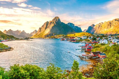 Küstenort Reine auf den Lofoten mit bunten Häusern und Bergen im Hintergrund