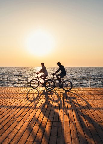 Paar fährt Fahrrad am Meer