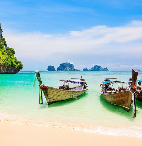 Traditionelle Boote am ruhigen Strand von Ko Samui mit klarem Meer und Himmel