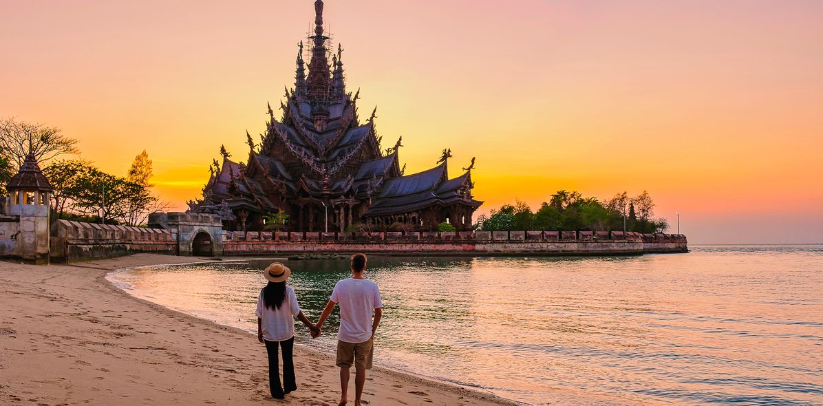 Paar am Strand mit Tempel bei Sonnenuntergang