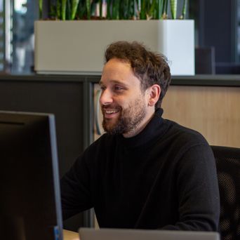 Mitarbeiter Felix Turra sitzt an seinem Arbeitsplatz