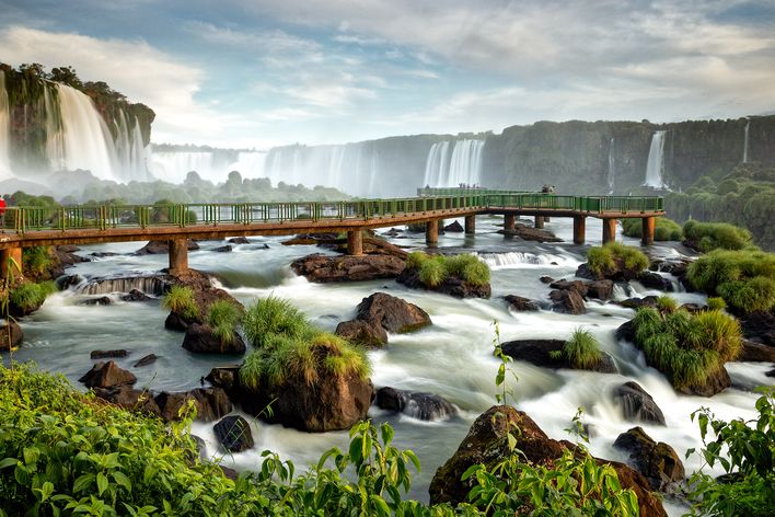 Blick auf die Iguazú-Wasserfälle mit begrünten Felsen und rauschenden Wasserkaskaden in Brasilien