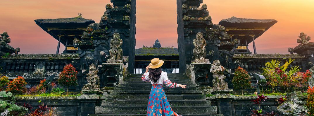 Frau steht vor dem Besakih-Tempel auf Bali bei Sonnenaufgang
