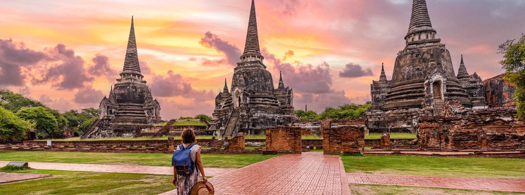 Eine Frau wandert durch die Tempelanlage von Wat Pra Si Sanphet in Ayutthaya in Thailand