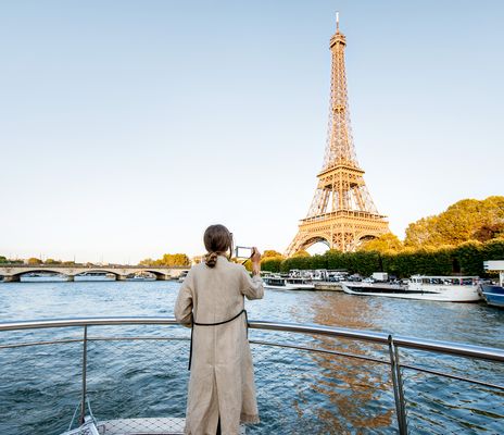 Frau auf einem Flusskreuzfahrtschiff fotografiert den Eifelturm in Paris