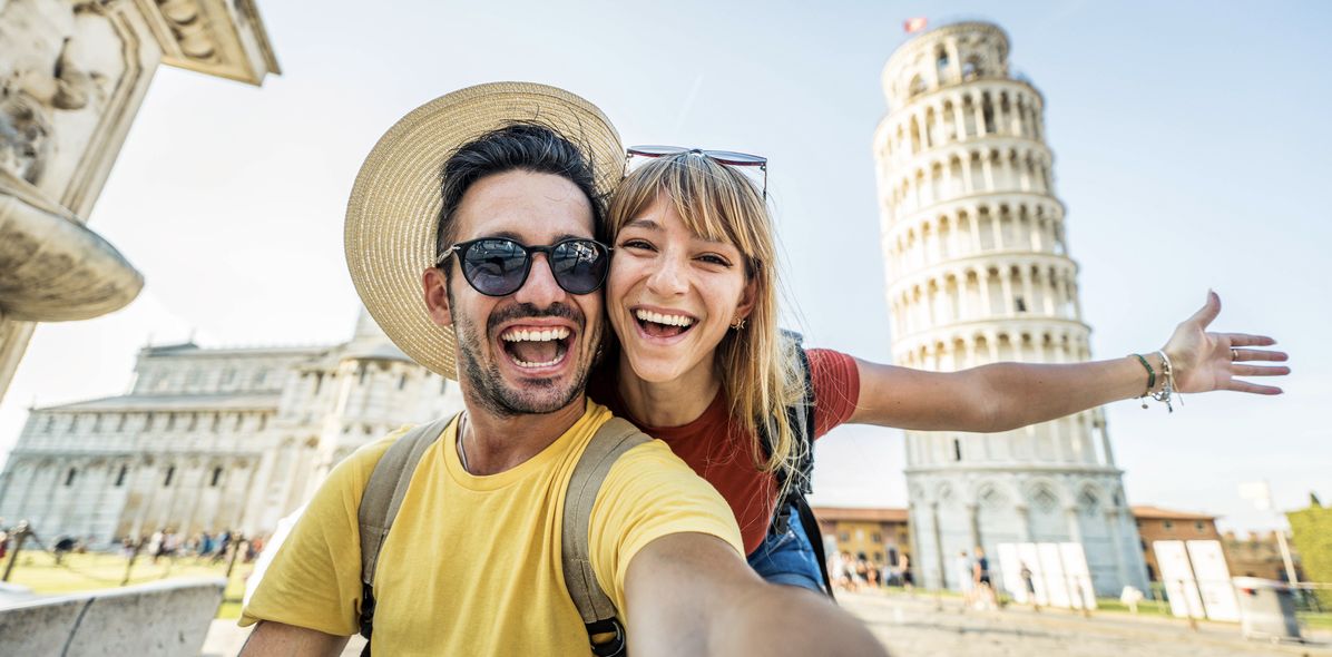 Mann und Frau machen Selfie vor dem Schiefen Turm von Pisa in Italien
