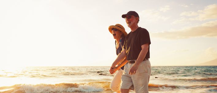 Fröhliches Paar spaziert am Strand