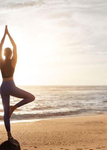 Frau macht Yoga am Strand