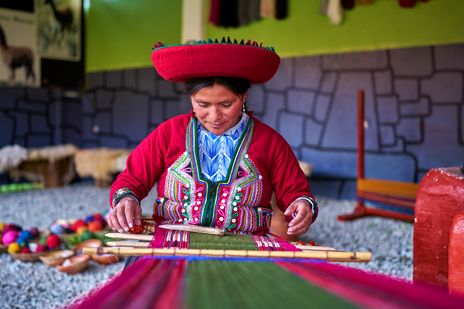 Indigene Frau in traditioneller Tracht bei Handwerksvorführung in Peru