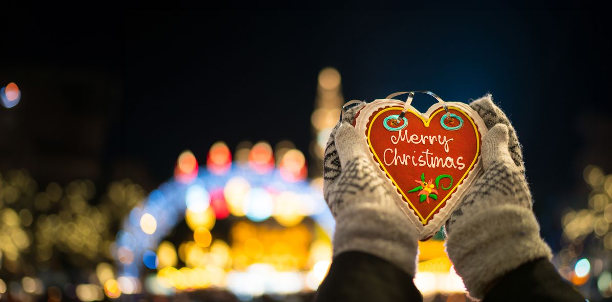 Person hält Lebkuchenherz am Weihnachtsmarkt