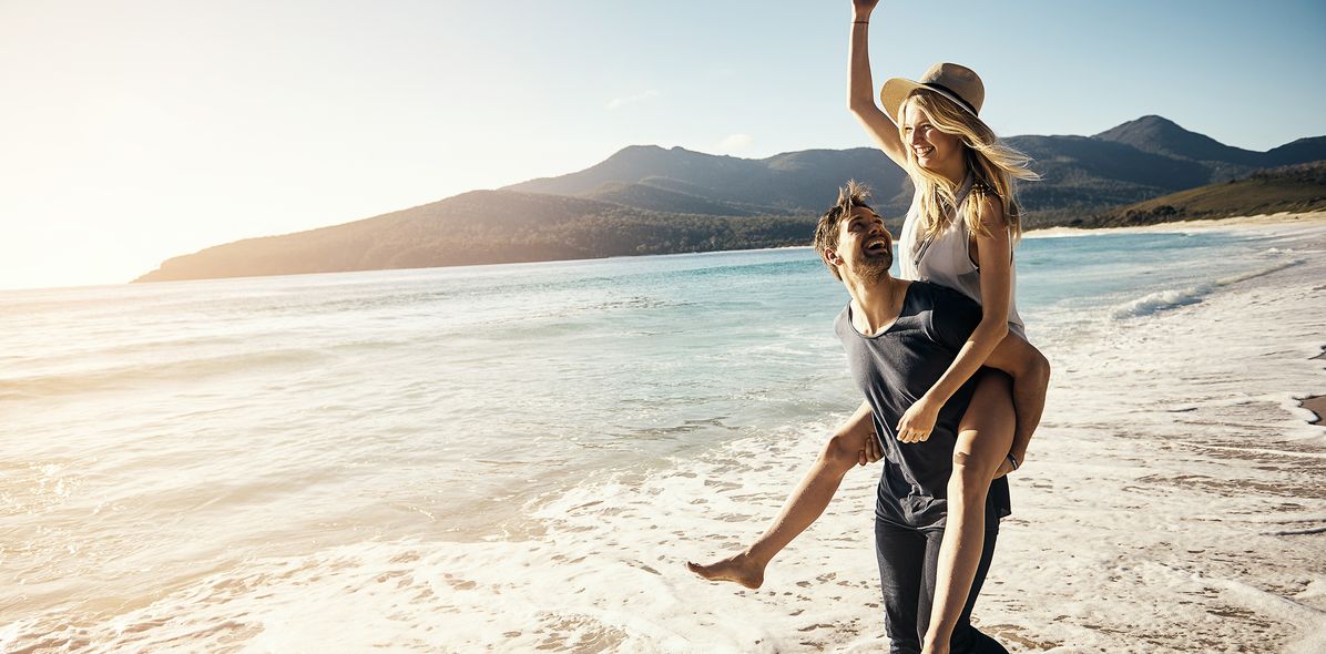 Paar im Huckepack am Strand