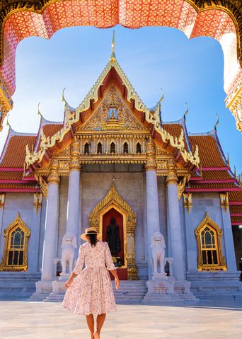 Eine Frau in Bangkok vor einem Tempel