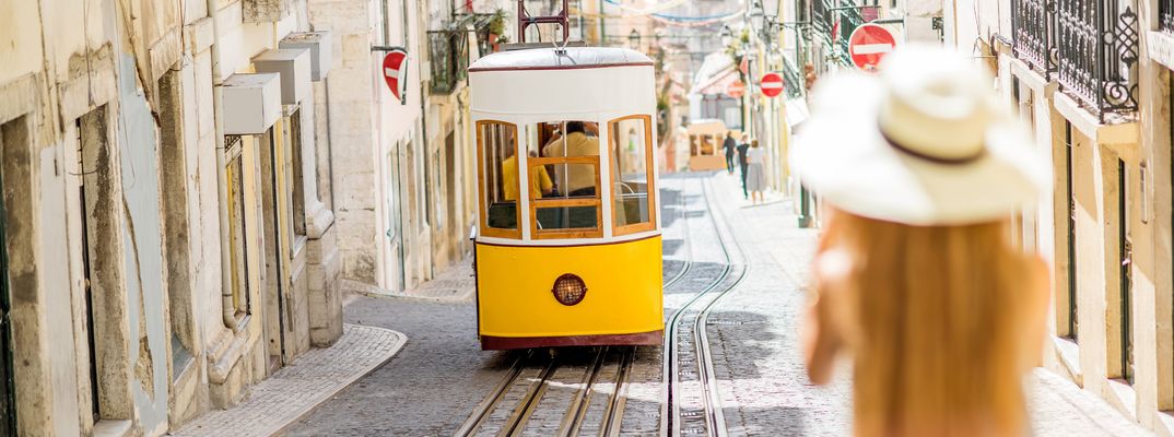Frau fotografiert Straßenbahn in Lissabon