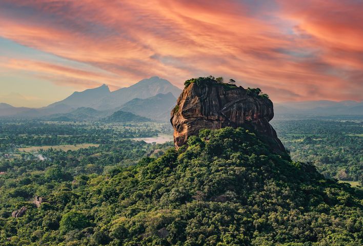 Der mächtige Löwenfelsen Sigiriya im goldenen Licht des Sonnenuntergangs, umgeben von tropischem Dschungel