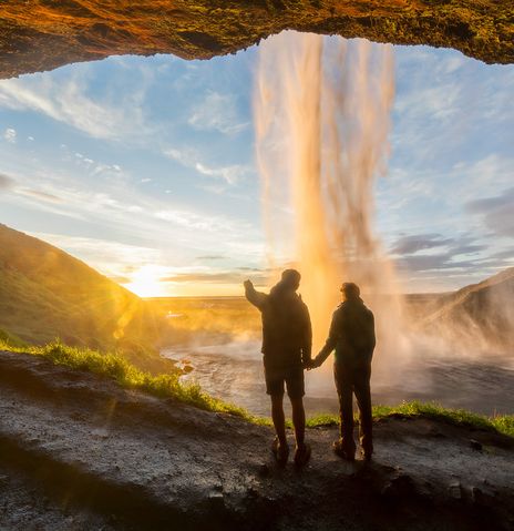 Paar vor dem Seljalandsfoss bei Sonnenaufgang