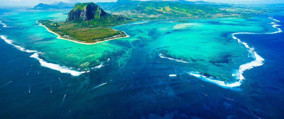 Luftaufnahme von Mauritius mit Blick auf türkisfarbendes Meer und Berge