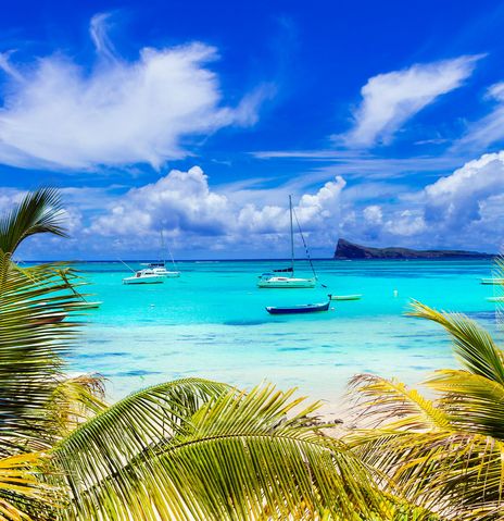 Strand von Cap Malheureux auf Mauritius mit Palmen, türkisblauem Meer und Booten