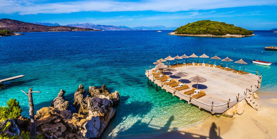 Der malerische Strand von Ksamil an der albanischen Riviera mit türkisfarbenem Wasser und kleinen Inseln