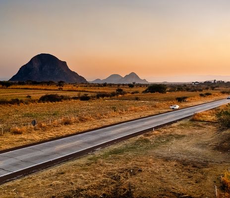 Landstraße durch die weite Landschaft Mexikos bei Sonnenuntergang