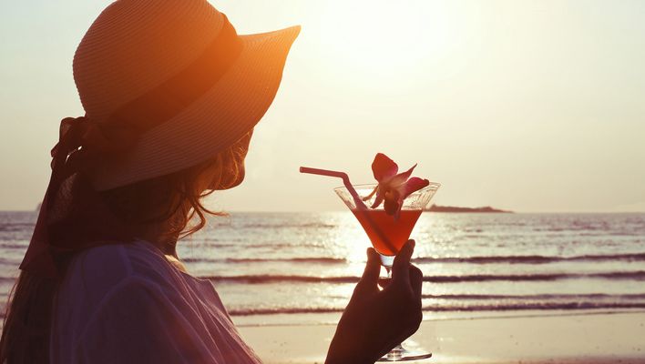 Frau trinkt Cocktail am Strand