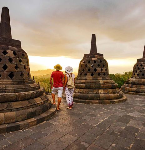 Paar mit Sonnenhüten blickt beim Borobudur Tempel auf der Insel Java in die Ferne