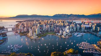 Skyline von Vancouver bei Sonnenuntergang mit Hafen und Bergen