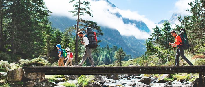 Zwei Erwachsene und zwei Kinder beim wandern in einer alpinen Berglandschaft