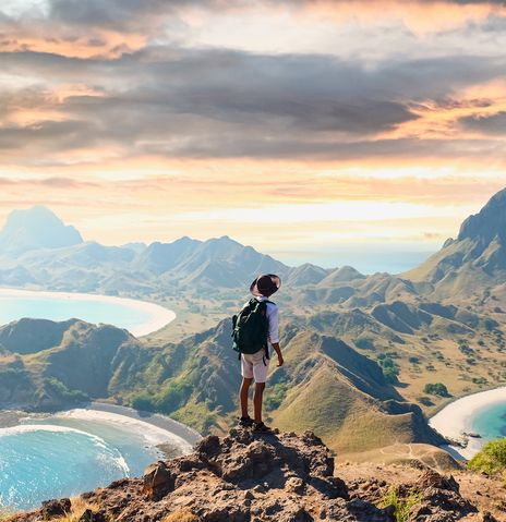 Mann mit Rucksack blickt im Komodo-Nationalpark auf der Insel Padar in Indonesien