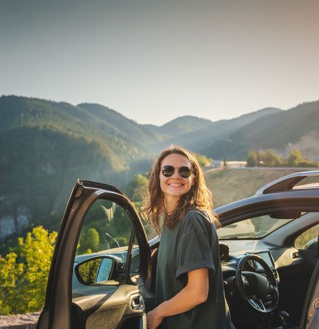 Frau steigt aus einem Auto aus