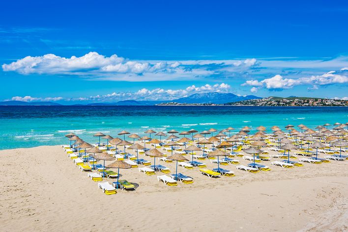 Feinsandiger Ilıca Strand bei Çeşme mit klarem Wasser und Sonnenschirmen