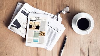 Tablet, Zeitung und Kaffee auf Holztisch