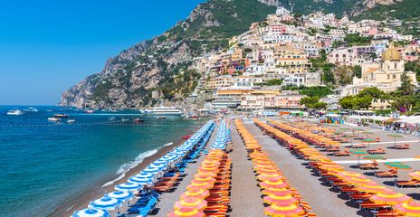 Strand von Positano mit bunten Sonnenschirmen und Amalfiküste