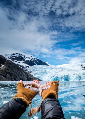 Hände zeigen auf eine Eiswand eines Gletschers mit blauem Eis in Alaska