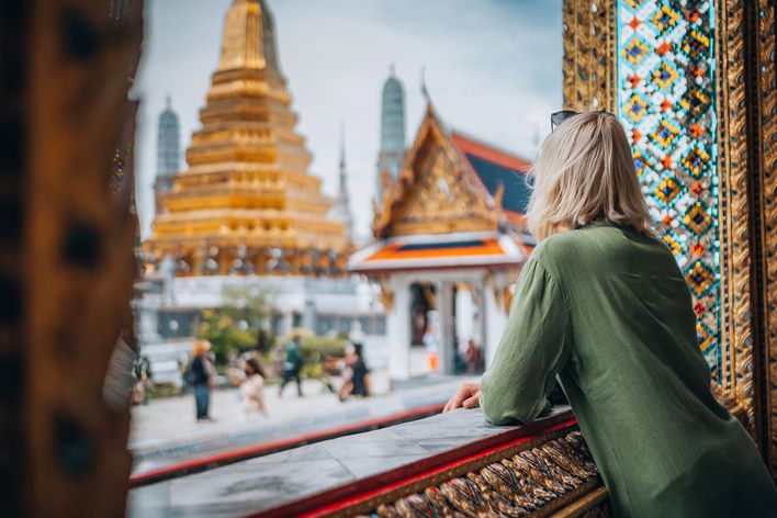 Frau blickt auf Tempel in Bangkok