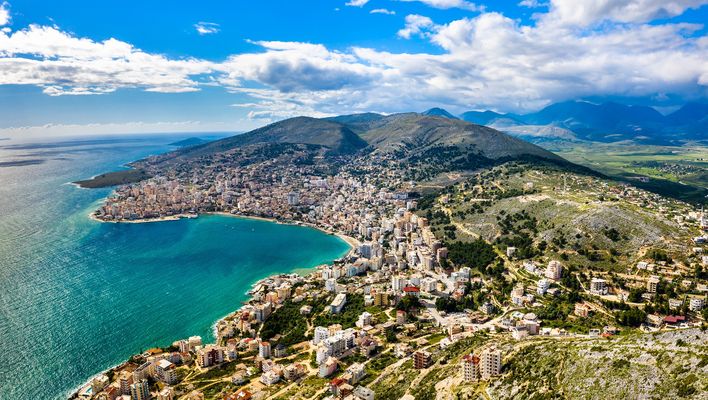 Luftaufnahme von Strand, Meer & Bergen von Saranda in Albanien