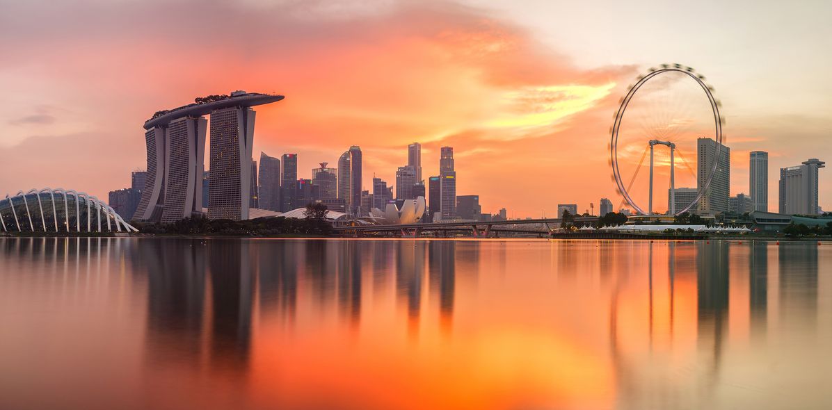 Blick auf Singapur mit Riesenrad bei Sonnenuntergang