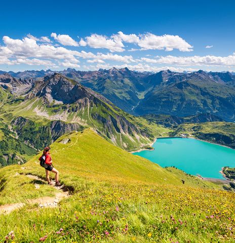 Frau steht auf Berg mit Ausblick