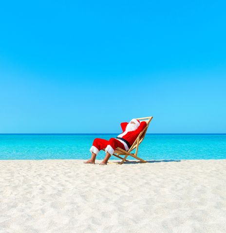 Weihnachtsmann im Liegestuhl am Strand